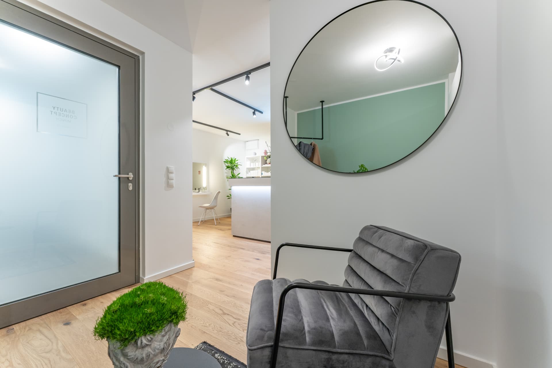Wartebereich mit rundem Spiegel und Sessel im Kosmetikstudio Beauty Concept Munich in München Au-Haidhausen